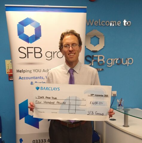 SFB Client Manager Dean Cart lifts a cheque for £400, contributing towards the £580 he has raised so far